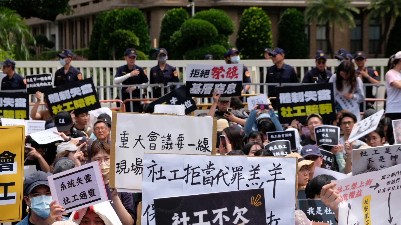 抗議現場有人高舉「社工拒當替罪羔羊」的標語。攝／曾玉婷