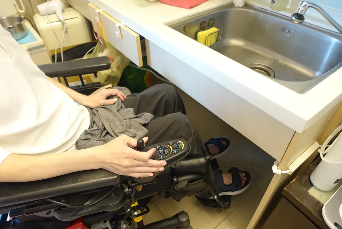 無障礙房常見流理臺下方容膝空間狹小,輪椅使用者難以移位。圖為林逸群。攝/葉靜倫